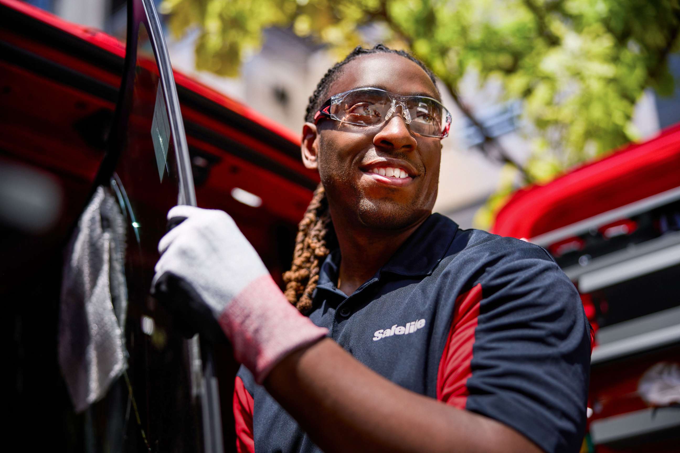 Safelite technician carrying glass in front of van