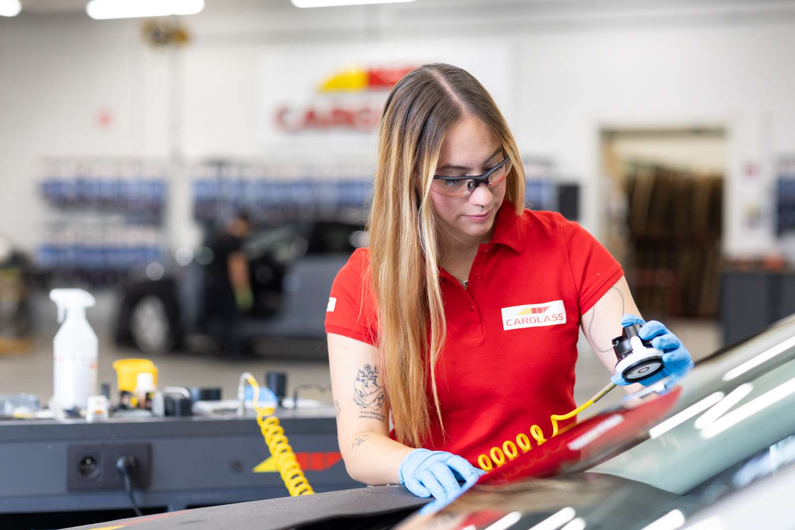 Female technician repairing a windscreen