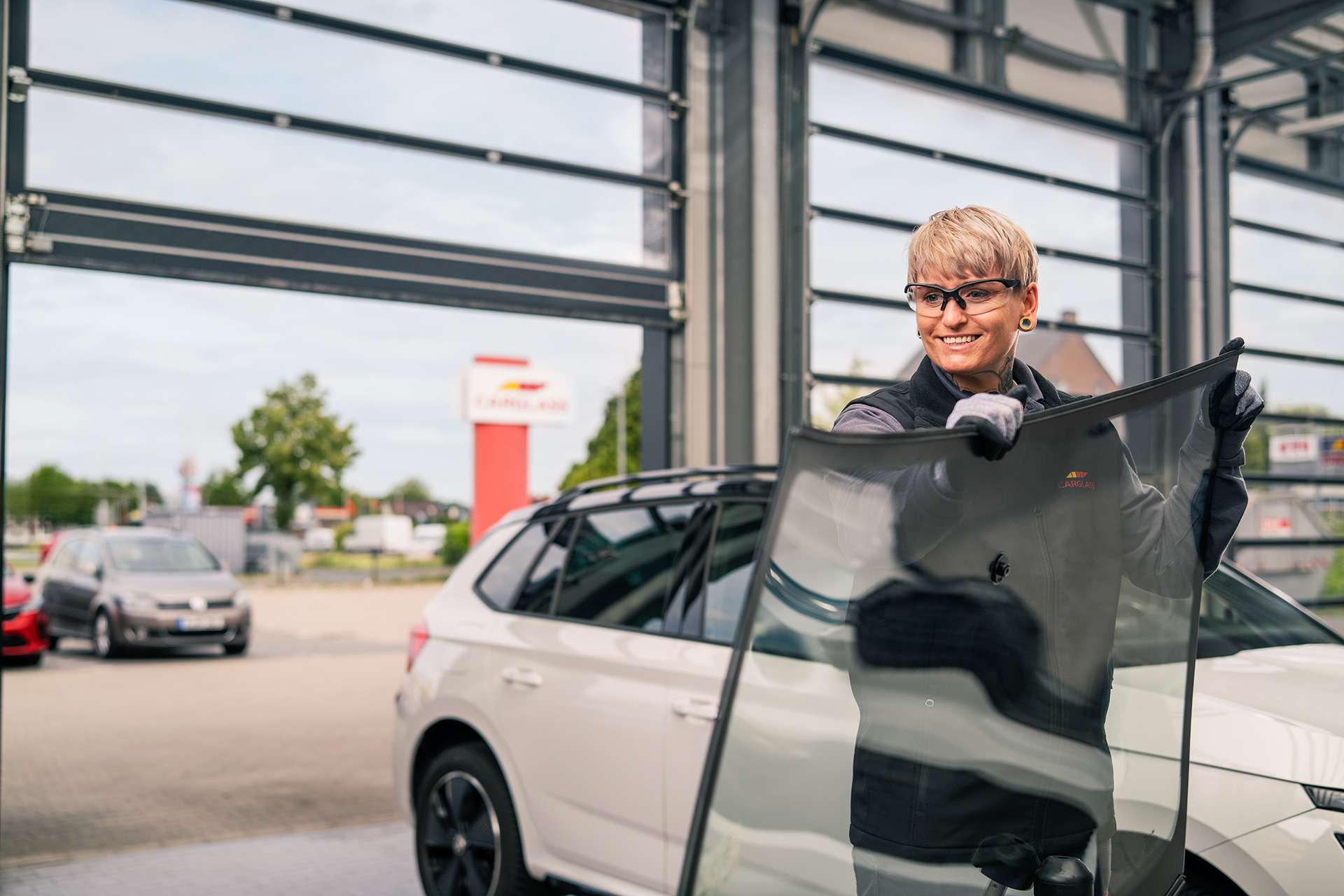 Female technician handling windscreen glass